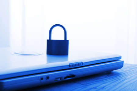 notebook and padlock showing internet or data security concept in blueの写真素材