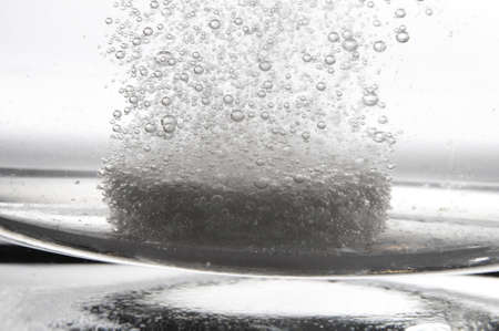 tablet or pain killer in a glass of water with copyspaceの写真素材