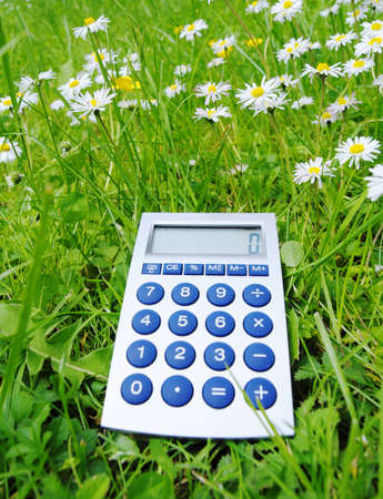 ecological accounting concept with calculator in green grassの写真素材
