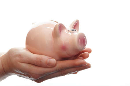 piggy bank or piggybank with hand isolated on white background showing savings conceptの写真素材
