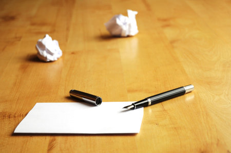 pen and paper in a wooden desktop showing creativity concept