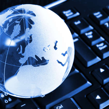 globalisation concept with glass planet on computer keyboard and copyspaceの写真素材