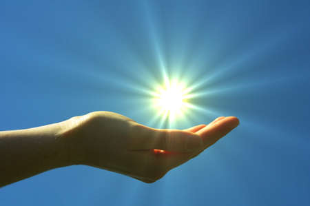 hand sun and blue sky showing hope peace or freedom conceptの写真素材