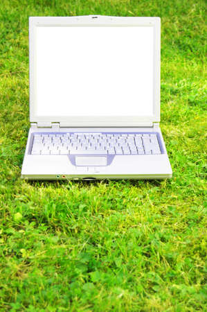 laptopn in green grass with blank or empty screen for copyspaceの写真素材