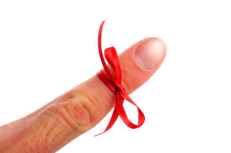 reminder concept with hand and red bow isolated on white backgroundの写真素材