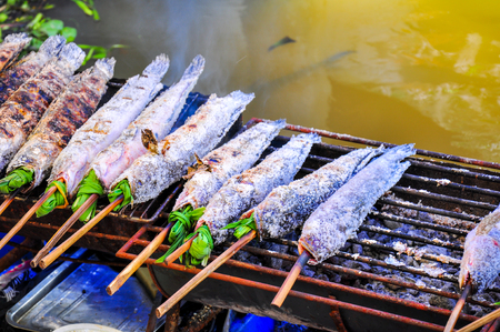Grilled fish with salt near river for Food travel in Thailand.の写真素材
