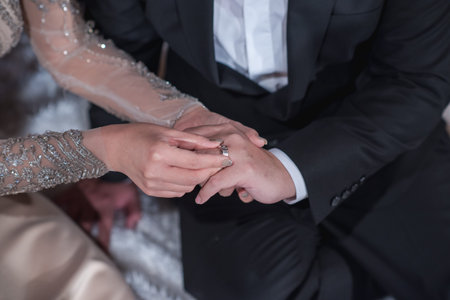 Hands of the groom and bride is wearing a ring on the finger on the day of the wedding ceremony....
