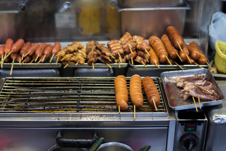 A fast food simply at local Asian Market. Street Food yakitori food. Thai local street Food. Sausage Grill on Street food in culture. Grilled Thai sausages on stove at Traditional Market, Thailandの写真素材