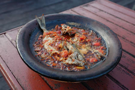processed chili sauce made from tomatoes and chilies cooked with fresh fish on a clay plate, a typical food from Indonesia, Bontang, East Kalimantan, in Indonesian this food is calの写真素材