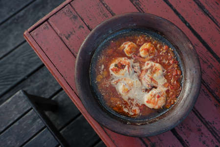 processed chili sauce made from tomatoes and chilies cooked with fresh fish on a clay plate, a typical food from Indonesia, Bontang, East Kalimantan, in Indonesian this food is calの写真素材