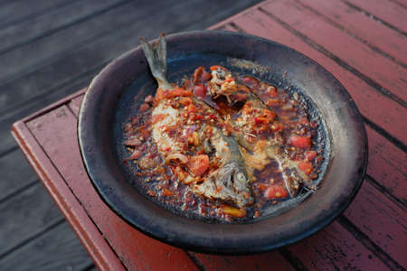 processed chili sauce made from tomatoes and chilies cooked with fresh fish on a clay plate, a typical food from Indonesia, Bontang, East Kalimantan, in Indonesian this food is calの写真素材
