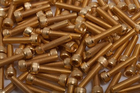 a pile of gold plated screws on white backgroundの写真素材