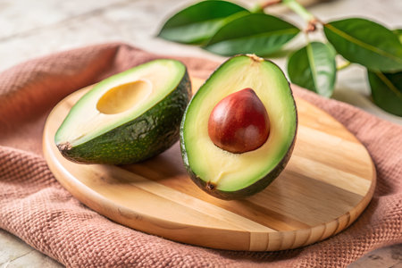 A close-up shot of a perfectly ripe avocado, showcasing its smooth, dark green skin and the slight give when pressed. The avocado is ready to be sliced open and enjoyed in various culinary creations.の写真素材
