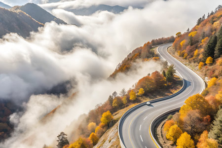 A thick fog blankets the winding mountain pass, obscuring the road and creating a mysterious and...