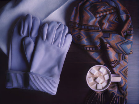 A warm and inviting flatlay featuring knitted mittens and scarves, accompanied by a mug of hot chocolate. Perfect for winter themes.の写真素材