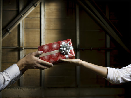 Two people exchanging beautifully wrapped gifts. A moment of generosity and holiday spirit.の写真素材