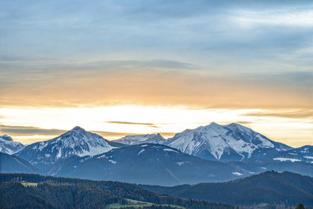 Majestic snow-covered mountains at sunrise, showcasing a beautiful, colorful sky.の写真素材
