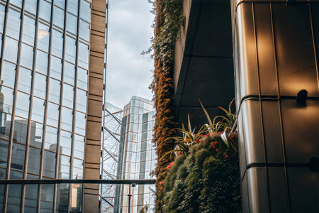 Modern buildings with a vibrant green wall, showcasing a blend of architecture and nature in a city...