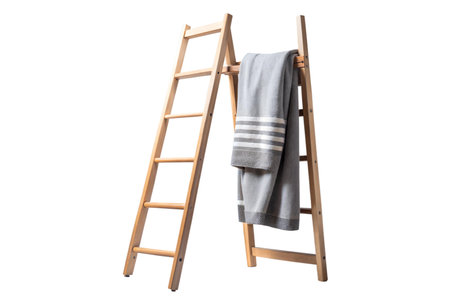 A grey throw blanket with white stripes is draped over a freestanding wooden ladder. The ladder is light brown and has five rungs.の写真素材