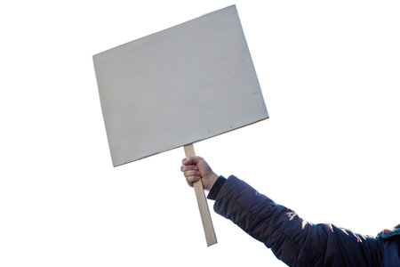Close-up of a person's arm holding a blank sign, isolated on a black background.  Suitable for protest, demonstration, or message concepts.の写真素材
