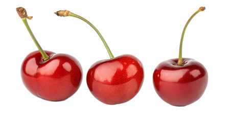 Close-up of three ripe cherries with stems, isolated on a black background.  The cherries are shiny and red.の写真素材