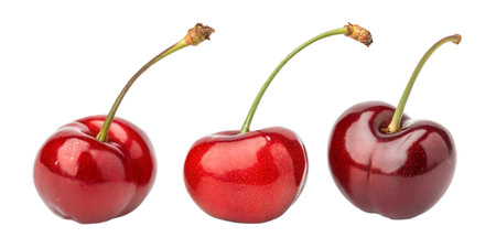 Three perfect cherries with stems on a black background.の写真素材
