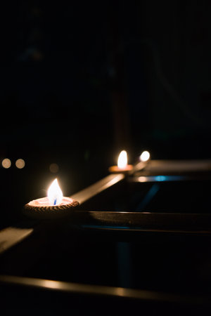 A close-up shot of candles burning in the dark, creating a warm and inviting atmosphere.の写真素材