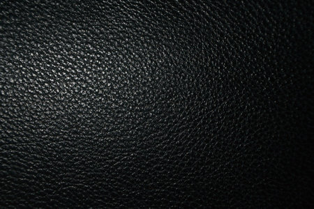 Close-up view of a dark black textured surface, possibly leather or synthetic material, showcasing...