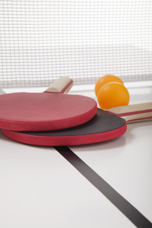 Black and red tennis table paddles with ballの写真素材