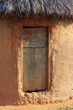 Simple mud hut with a wooden doorの写真素材