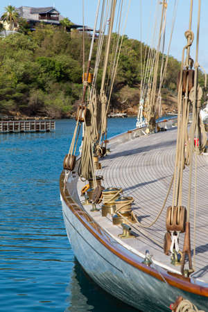 Beautiful classic yacht moored in Falmouth Antigua with villas in the backgroundの写真素材