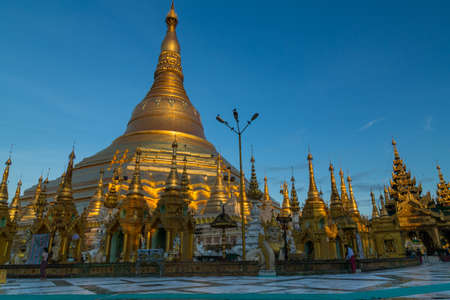 The iconic Shwedagon pagoda glows in a beautiful soft gold light at dawn - landscapeのeditorial素材