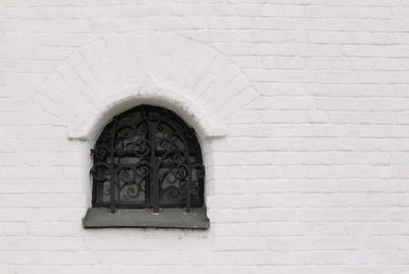 barred window in the brick thick wallの写真素材