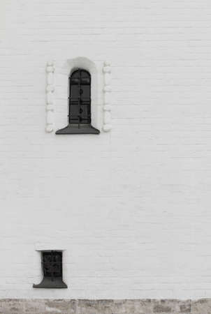 barred a narrow window in the brick thick wallの写真素材