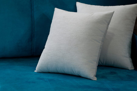 Beige pillows on a blue sofa creating a cosiness in the house