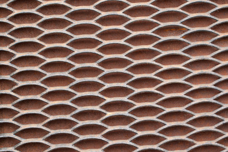 metal coarse and strong grating with rhythmically located holes on a rusty background