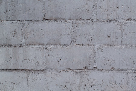 Old dilapidated wall of concrete blocks painted in grayの写真素材