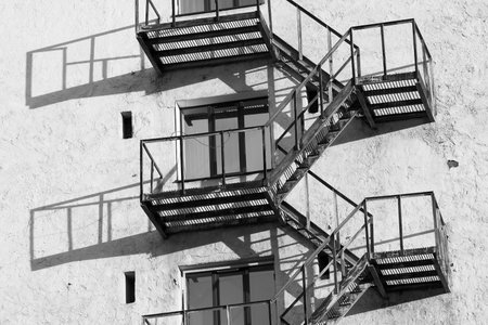 rusty fire escape with balconies on the facade of an old town house