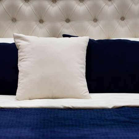 comfortable bed made with white and blue pillows and a bedspreadの写真素材
