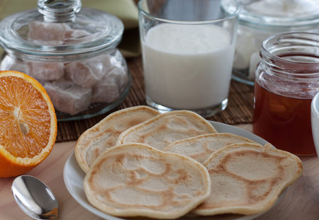 on a wooden table covered with a wicker napkin, there is food for a healthy tasty breakfast,...