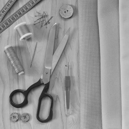 sewing accessories, tailor's scissors, sewing threads, cloth and tracing paper lie on a beautiful wooden table. everything is prepared for cutting and sewing clothesの写真素材