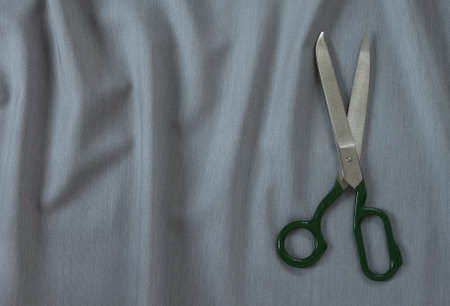 on gray fabric in small folds are tailor's scissors, backgroundの写真素材