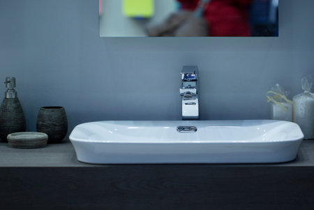fashionable modern washbasin with hygiene items in the bathroom of a cozy home or hotelの写真素材