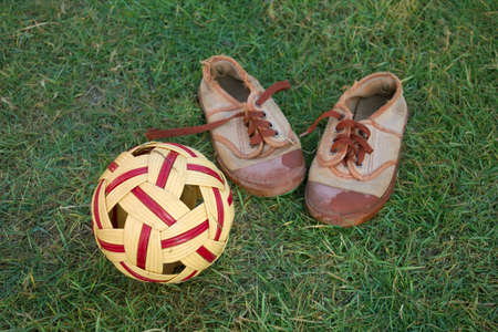 sepak takraw on green grass field and old shoesの写真素材