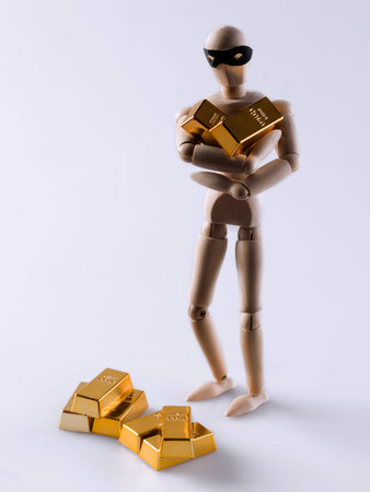 Wooden doll stealing some gold bullion