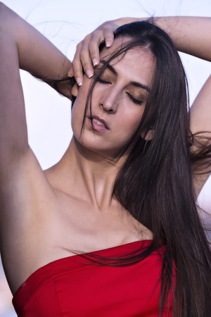 Portrait of a young woman holding her hair with his handsの写真素材