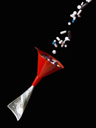 Pills and tablets through a funnel money to becomeの写真素材