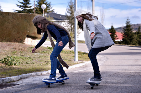 Two girls playing with a wave board. Skateboardの写真素材