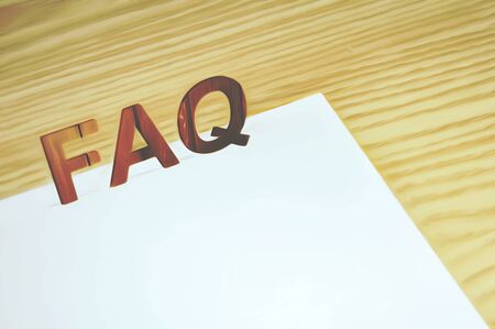 FAQ letters on a white paper over a wood tableの写真素材