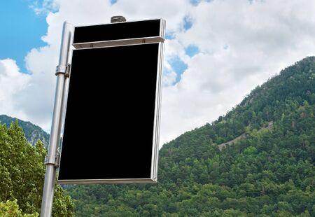 Big empty billboard against beautiful mountainous landscape with green forest の写真素材